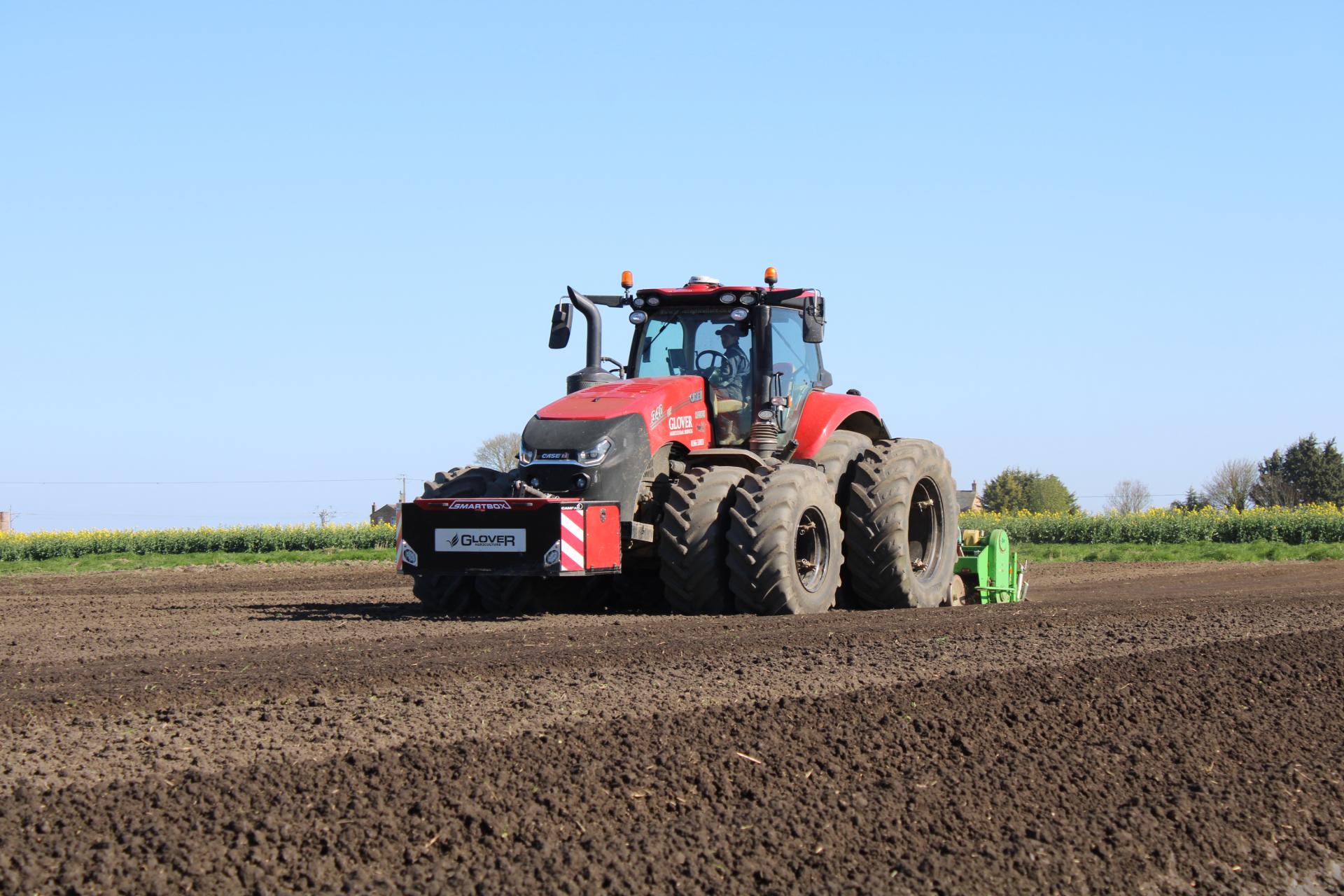 Glover red tractor in the filed for seed bed preparation