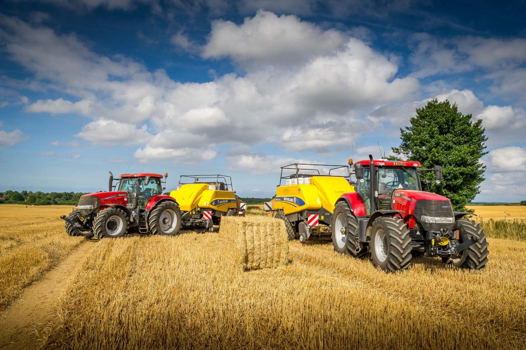 2 New Holland balers in a field
