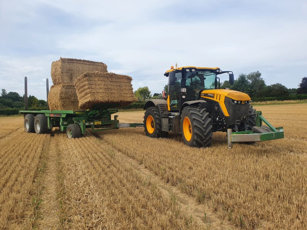 JCB Bale chasing in a field