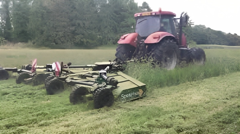 Tractor with setaside mower cutting tall grass