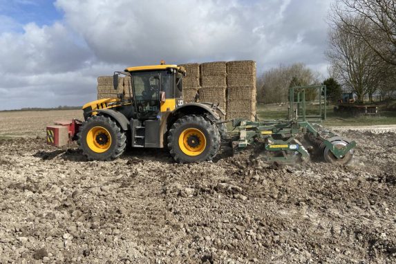 Yellow JCB tractor cultivating